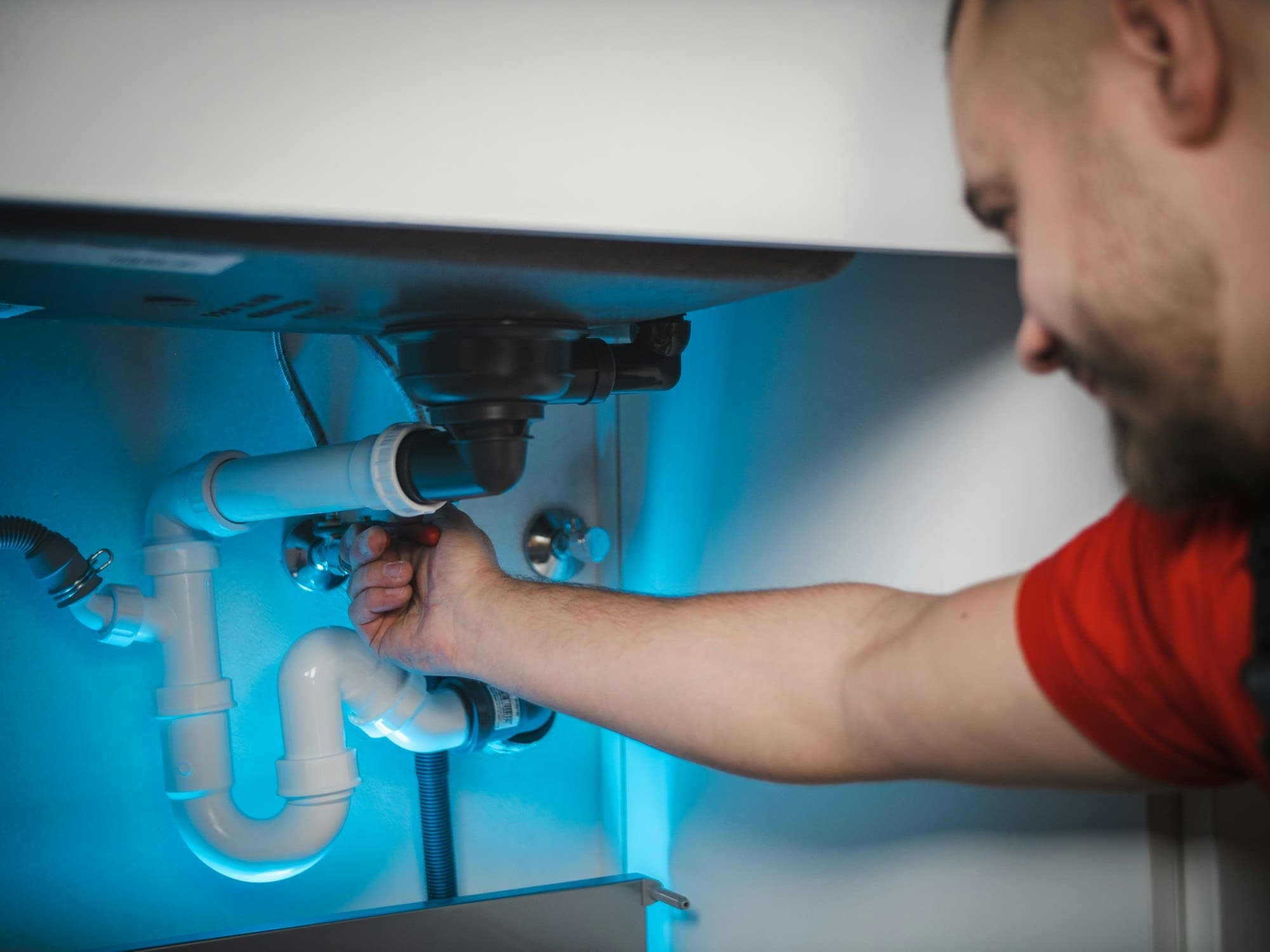 Installateur arbeitet unter einem Waschbecken