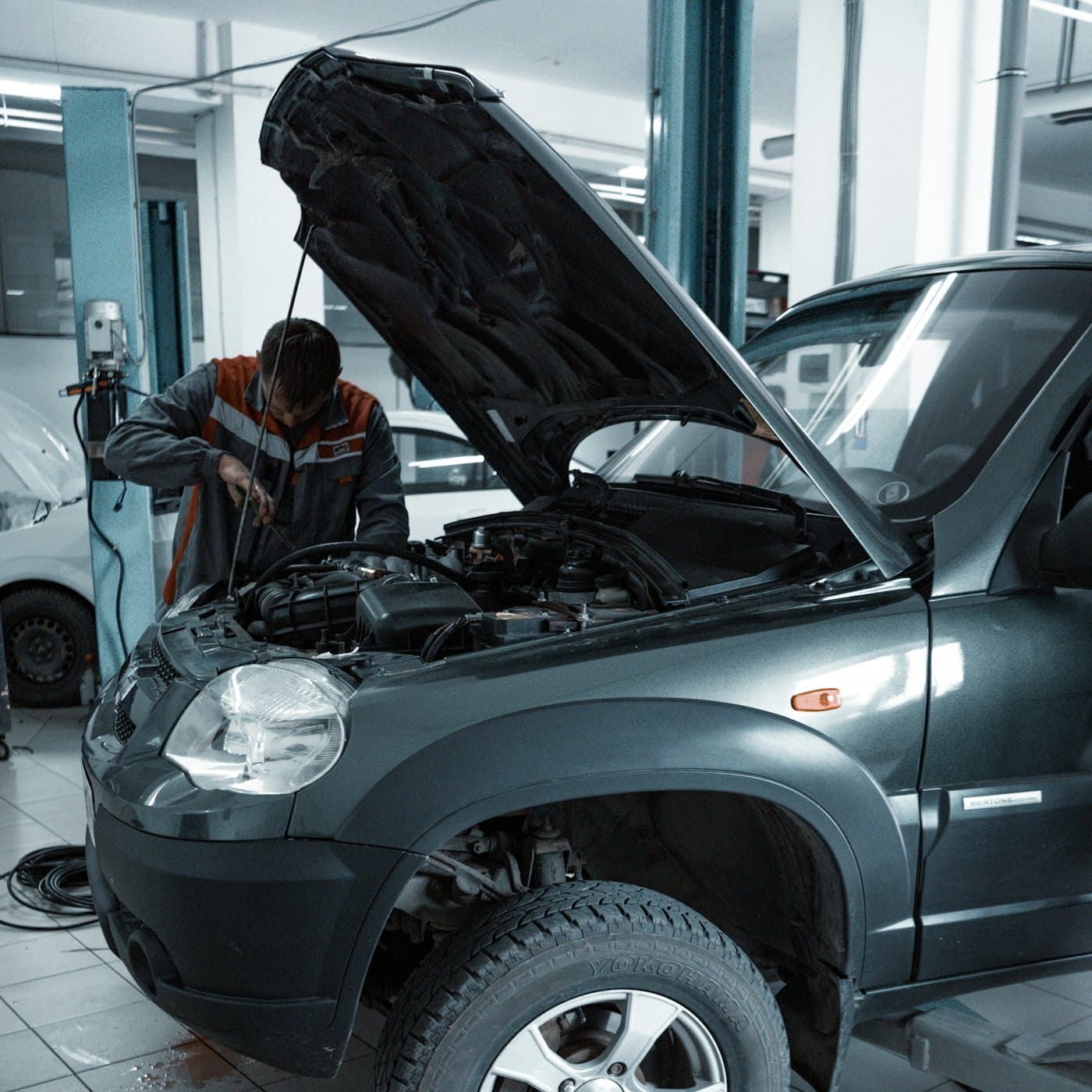 Mechaniker arbeitet unter der geöffneten Motorhaube